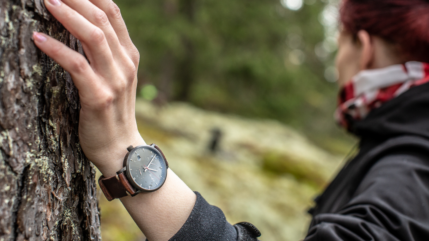 Woman leaning on a tree Adventurister Dark watch on her hand